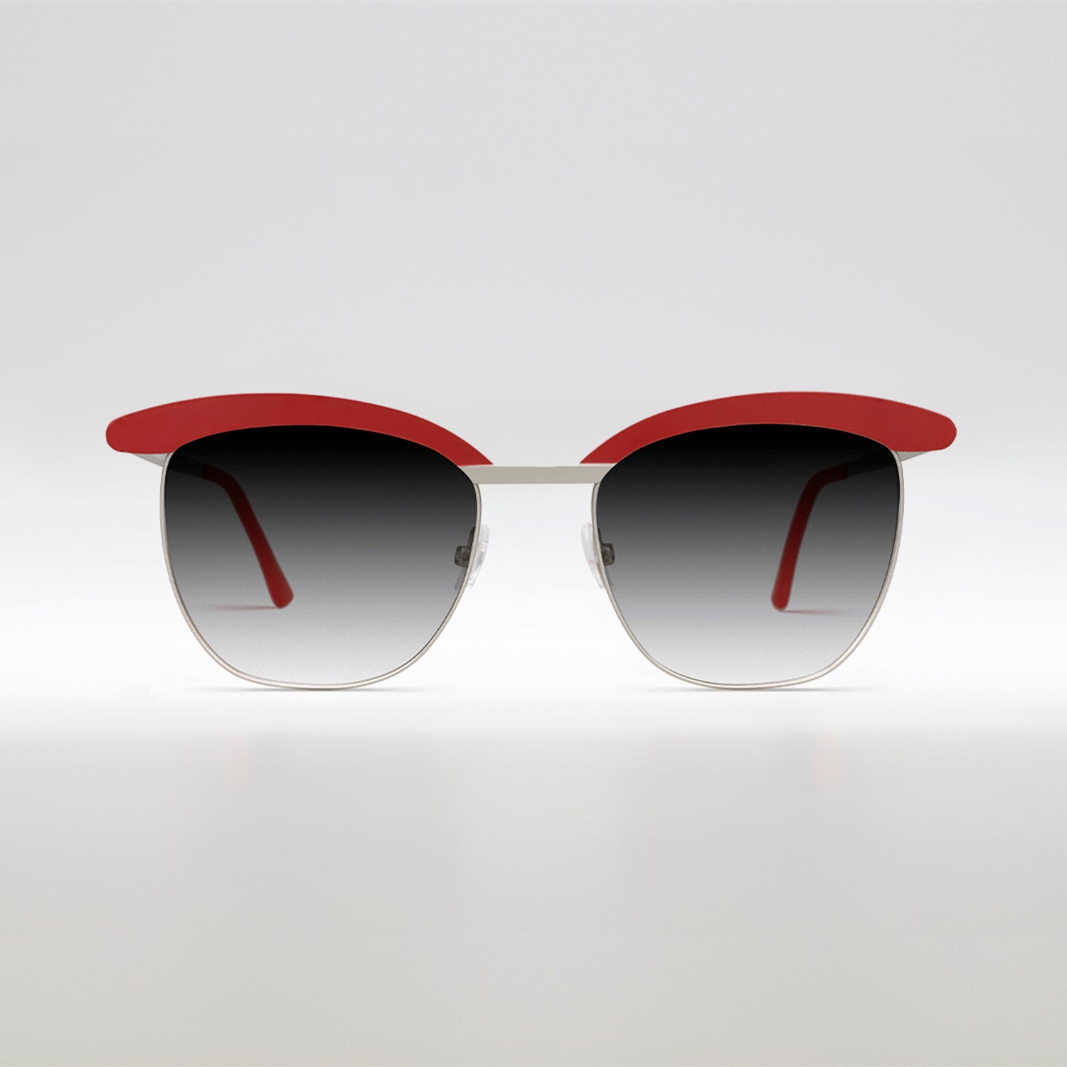 
                    
                      occhiali da sole con montatura rossa e lenti sfumate grigie vista frontale
                    
                  
